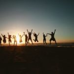 silhouette photography of group of people jumping during golden time