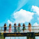 six women wearing dress leaning on bridge rail