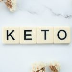 scrabble tiles surrounded by white flowers on a marbled surface