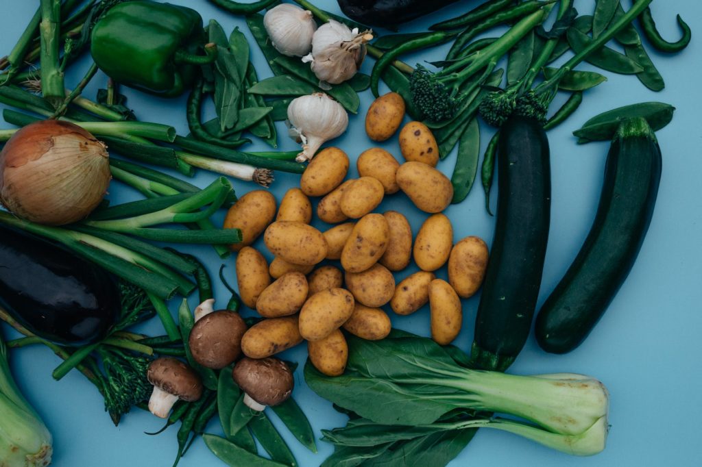 close up shot of variety of vegetables on a blue surface
