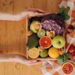 person holding a basket of fruits