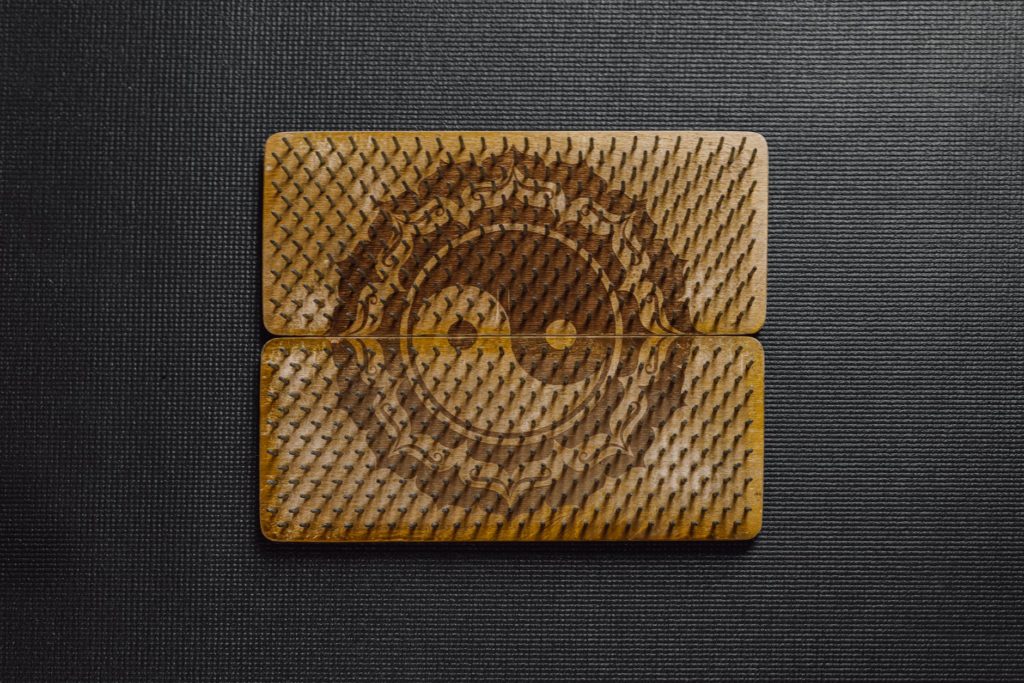 nails on wooden board with the ying yang symbol