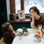 a mother and child leaning on the table