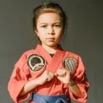 close up shot of a girl wearing red dobok and blue belt