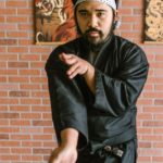 a man in black robe doing karate