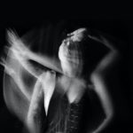 upset young woman touching face in darkness