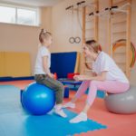 a mother and daughter sitting on exercise balls