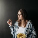 a woman eating a bowl of chips