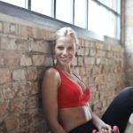 woman wearing red sports bra and black pants