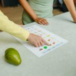 person in green shirt holding white printer paper